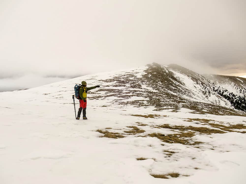 vista general de una montaña nevada y un montañero